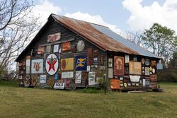Rustic barn covered in vintage metal signs e4BLe0