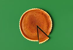 Homemade pumpkin pie isolated on a green background