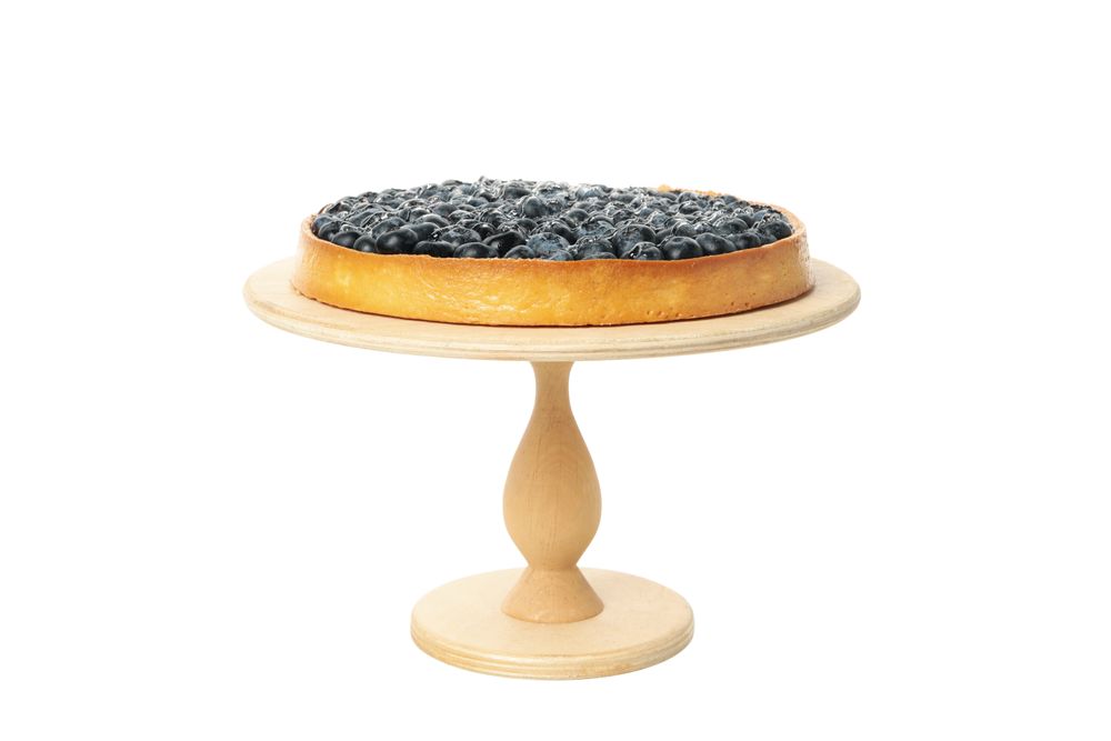 Wooden board with blueberry pie isolated on light background