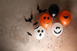 Different balloons on brown background. Halloween concept, space for text
