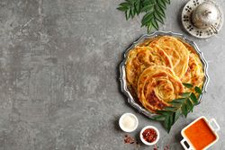 Top view of roti parata or roti canai with sauce and copy space