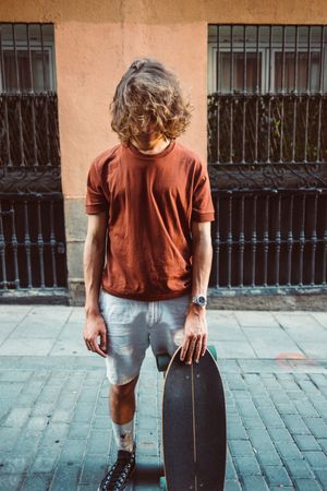 Man carrying longboard on the street