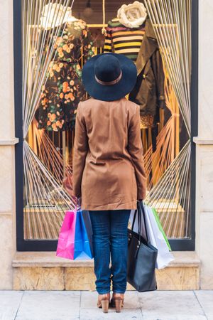 Charming woman in classy outfit shopping for dress