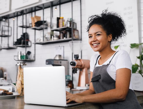 Happy business owner working in her coffeeshop