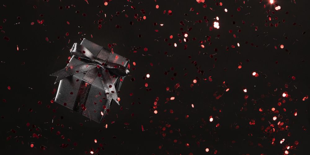 Dark gift with red glitter on background