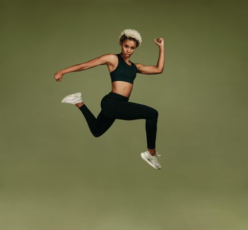 Woman doing stretches in air on green background