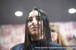 Brunette teenager with wet brunette hair sitting having a hair cut 497xQ0