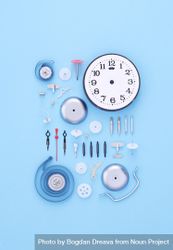 Neatly disassembled clock on blue background 0y9NW0