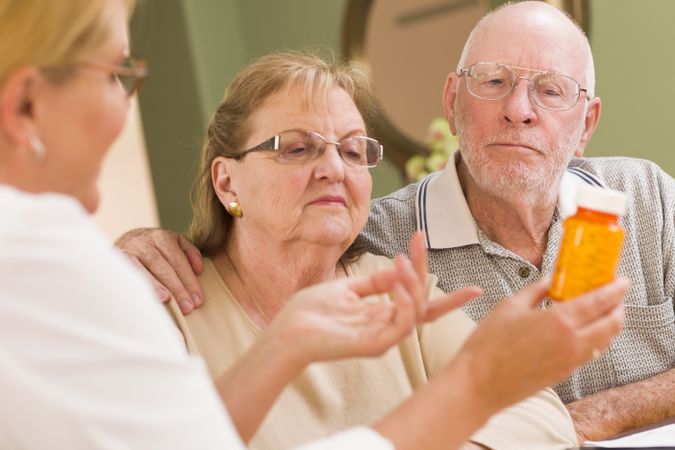 Doctor or Nurse Explaining Prescription Medicine to Older Couple