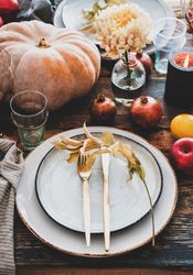 Fall table setting with squash, candles and pomegranates, close up