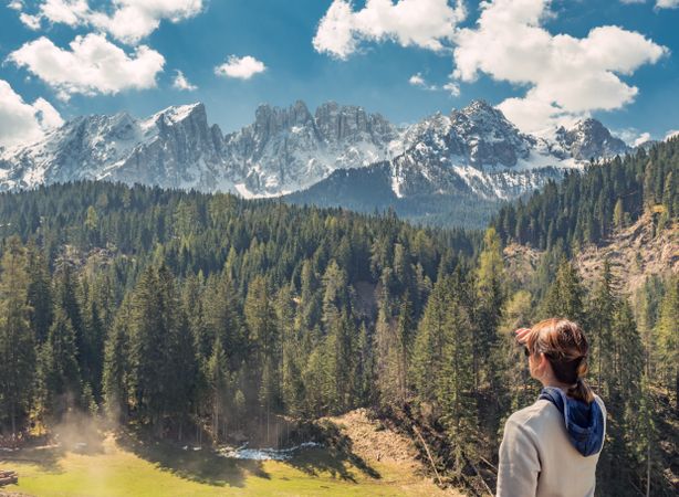 Woman covering face from sun and looking at amazing landscape