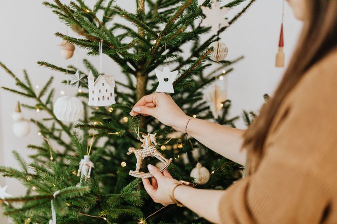 Cropped image of woman decorating Christmas tree