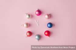 Clock hands with colorful pastel decoration balls on pink painted wall 0vkGB5