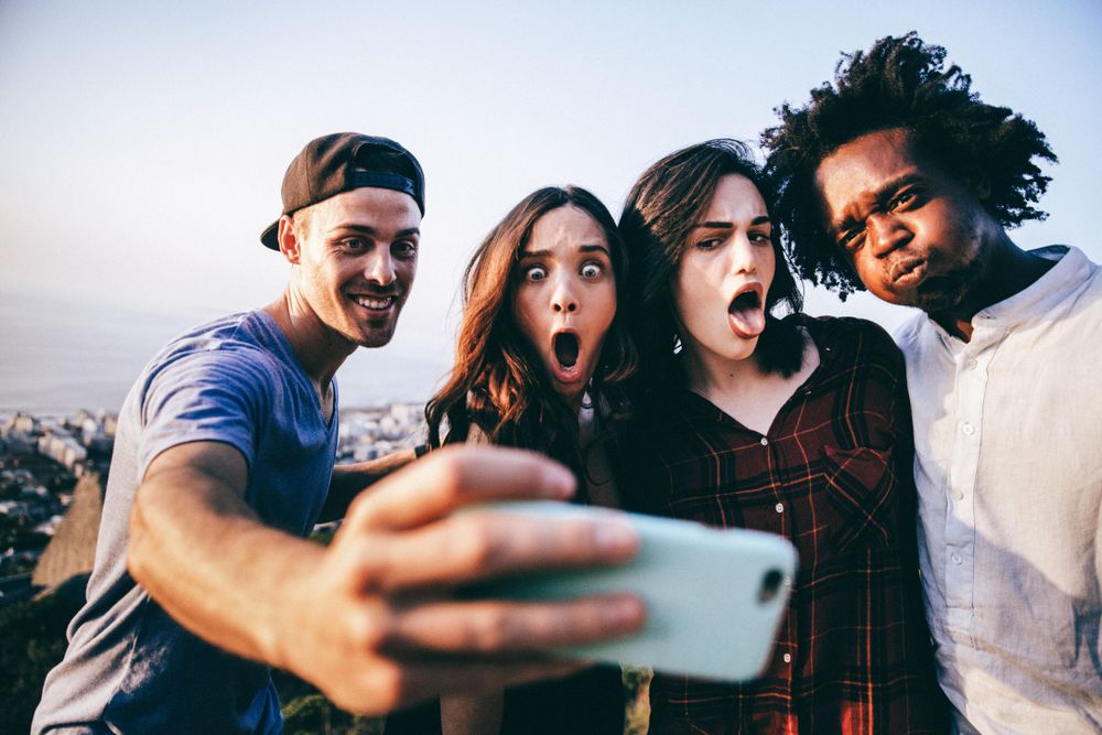 Group of friends taking a silly group selfie outside