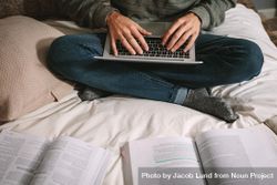 Young man studying at home sitting on bed 5lxPa5