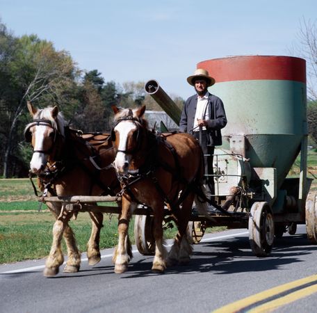 Amish man with farm equipment drawn by horses, Lancaster, Pennsylvania