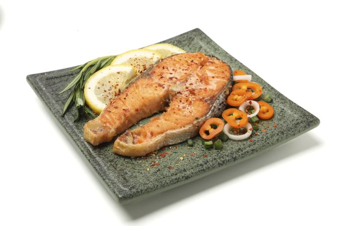 Plate with grilled salmon isolated on blank background
