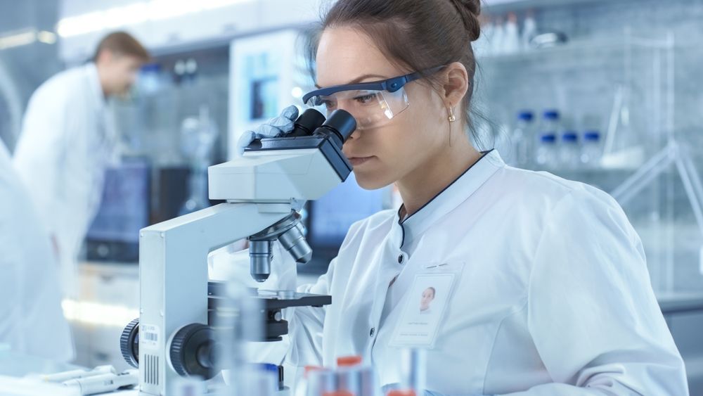 Medical Research Scientists Looking at Samples Under Microscope.