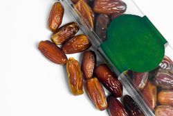 Dates fruit in plastic package with blank green label for product mockup design