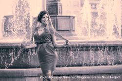 Elegant woman standing by European city fountain 5q2PY4