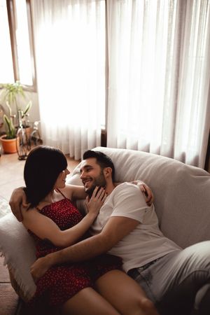 Cheerful couple hugging on sofa