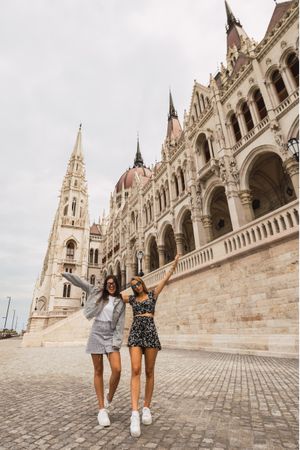 Funny girl friends on old square with dome buildings