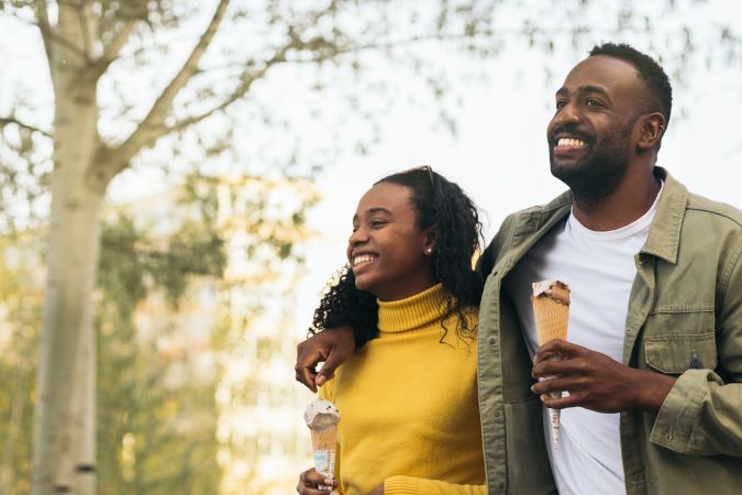 Black couple eating ice cream in a park