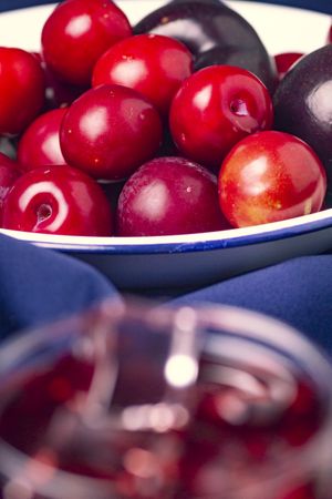 Red beverage near fresh fruits on cloth