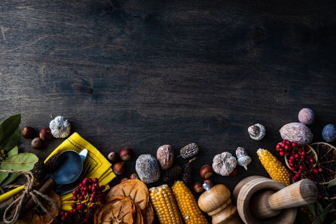 Autumnal harvest flatlay with nuts, berries, vegetable and fruits on dark wooden background with copy space