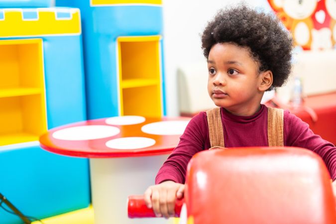 Cute boy with afro hair in kindergarden class