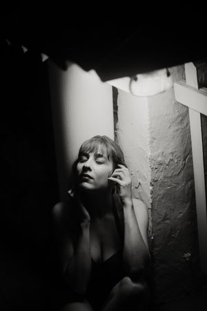 Silhouette of sensual woman leaning in shadow