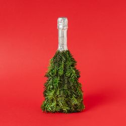 Champagne bottle Christmas tree concept on red background