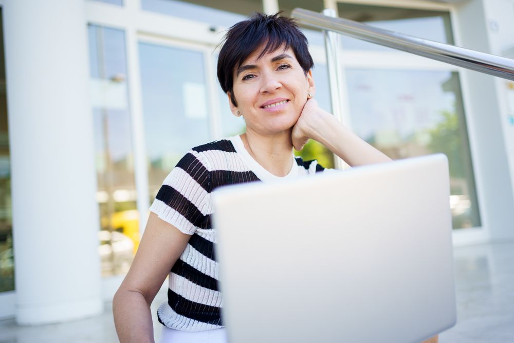 Portrait of woman behind laptop