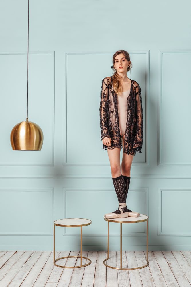 Ballerina posing on a turquoise background.