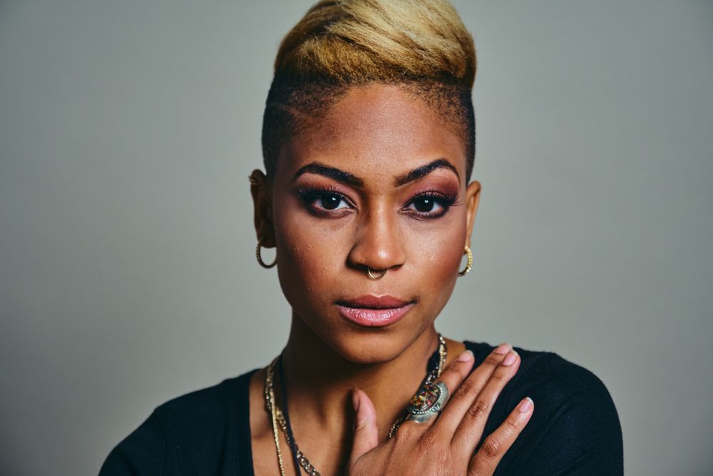 Closeup portrait of serious Black woman with septum piercing with hand to her chest