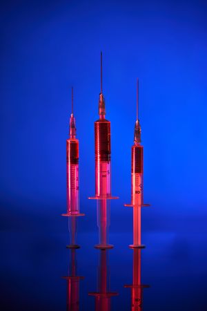 Syringes with vaccine in neon lighting
