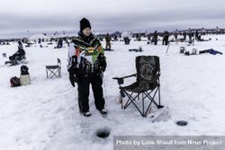 Nisswa, MN, USA - January 25th, 2020: Woman standing at her ice fishing hole 5rZYP5