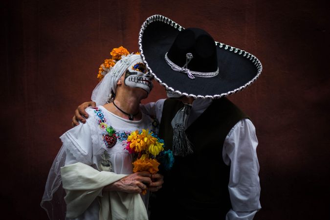 Mexican bride and groom with sugar skull face paint