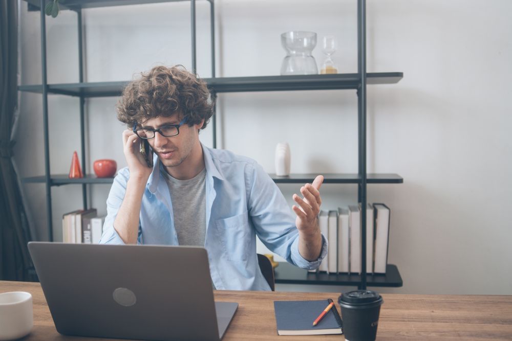 Creative designer talking on the phone while sitting at desk