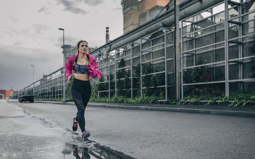 Sportswoman running in an industrial zone