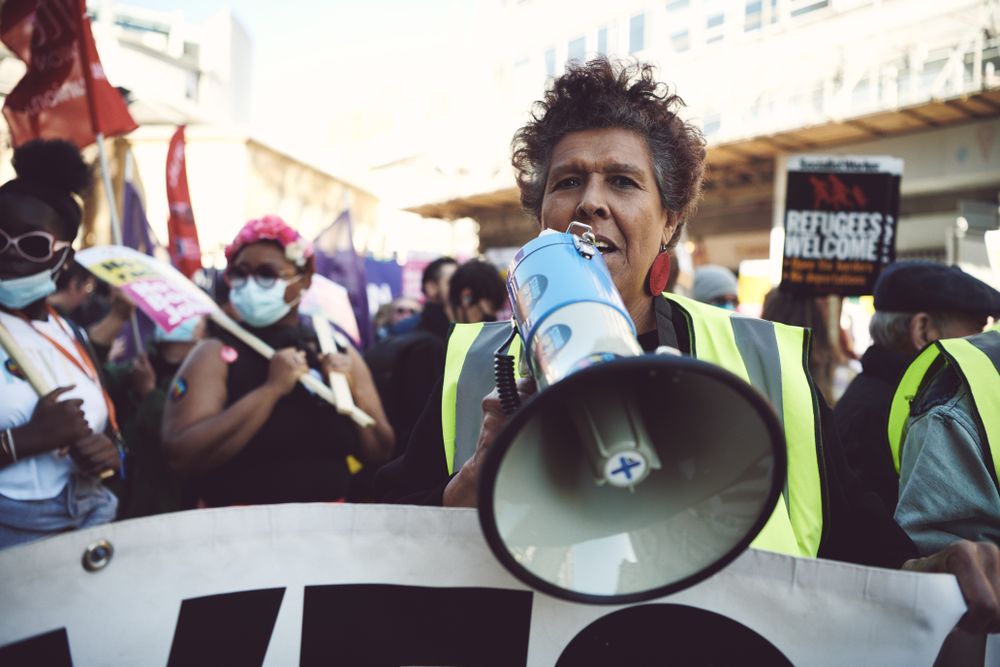 London, England, United Kingdom - March 19 2022: Short haired woman with loud speaker at protest