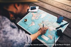 Man planning tour using world map 5pgvdv