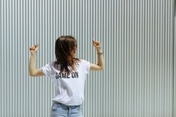 Young woman dancing near wall