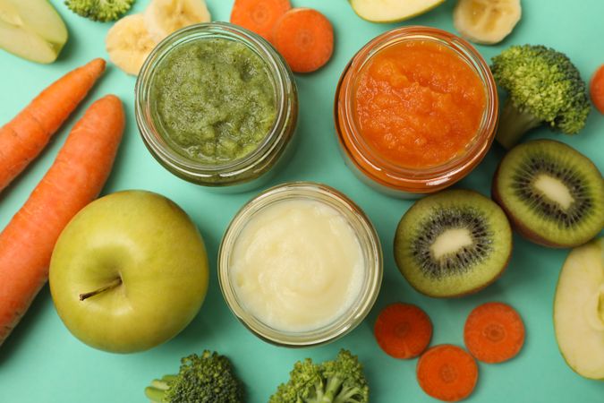 Composition with baby food on mint background, top view