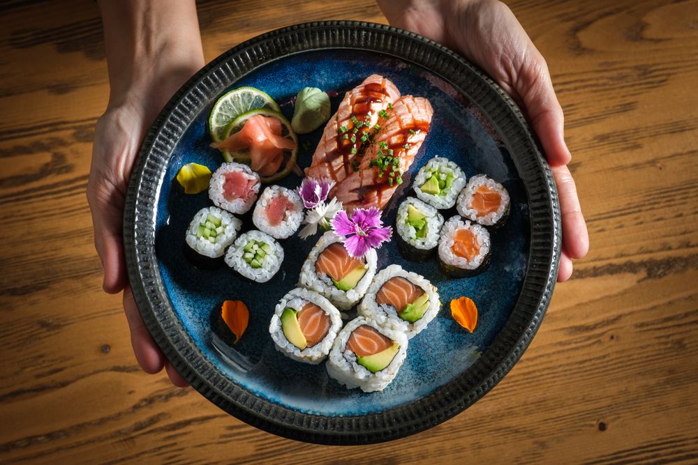 Person with plate with assorted sushi