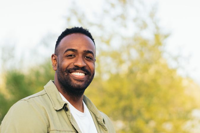 smiling Black young man portrait in a park