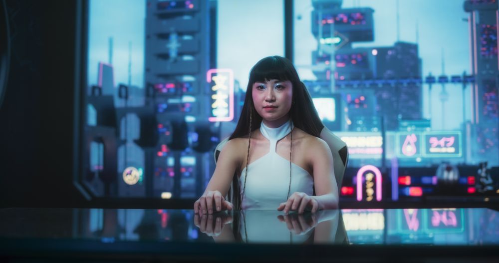 Stylish Japanese Woman Using Glass Interactive Desk with Futuristic Cyberpunk City in the Background.