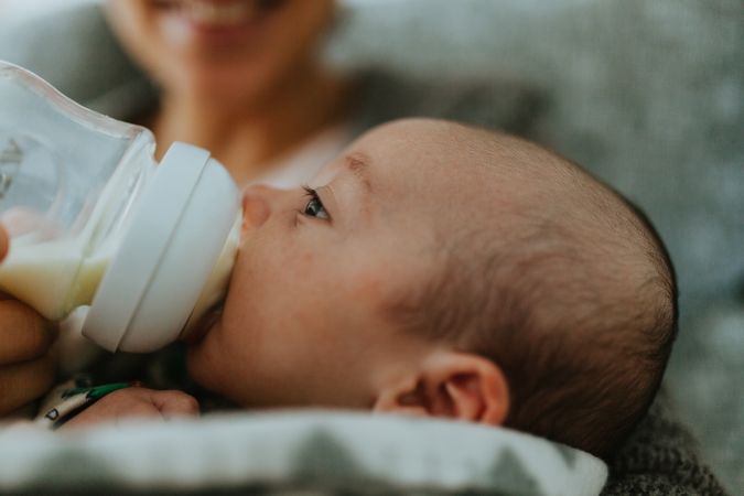 Side profile view of newborn being bottle fed