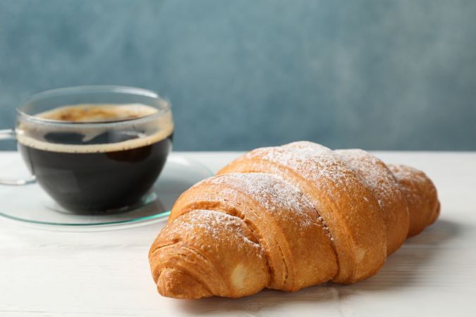 Croissants and cup of coffee in blue room
