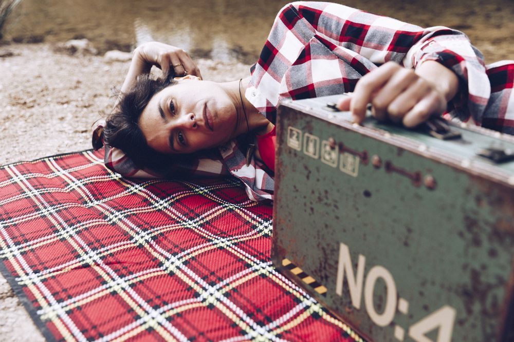 Cheerful woman with old case on picnic